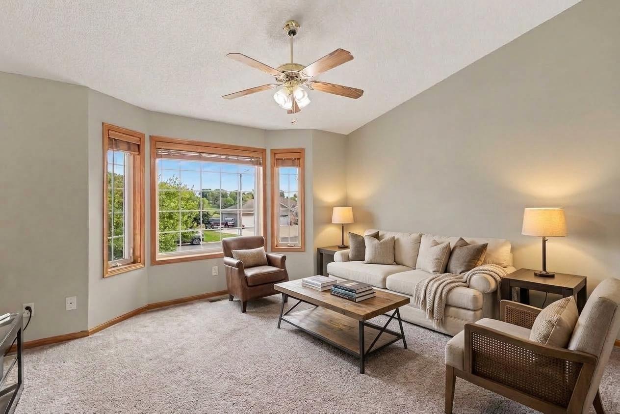 Main-level living room with vaulted ceiling and an open connection to the kitchen and dining area.(virtually staged).jpg