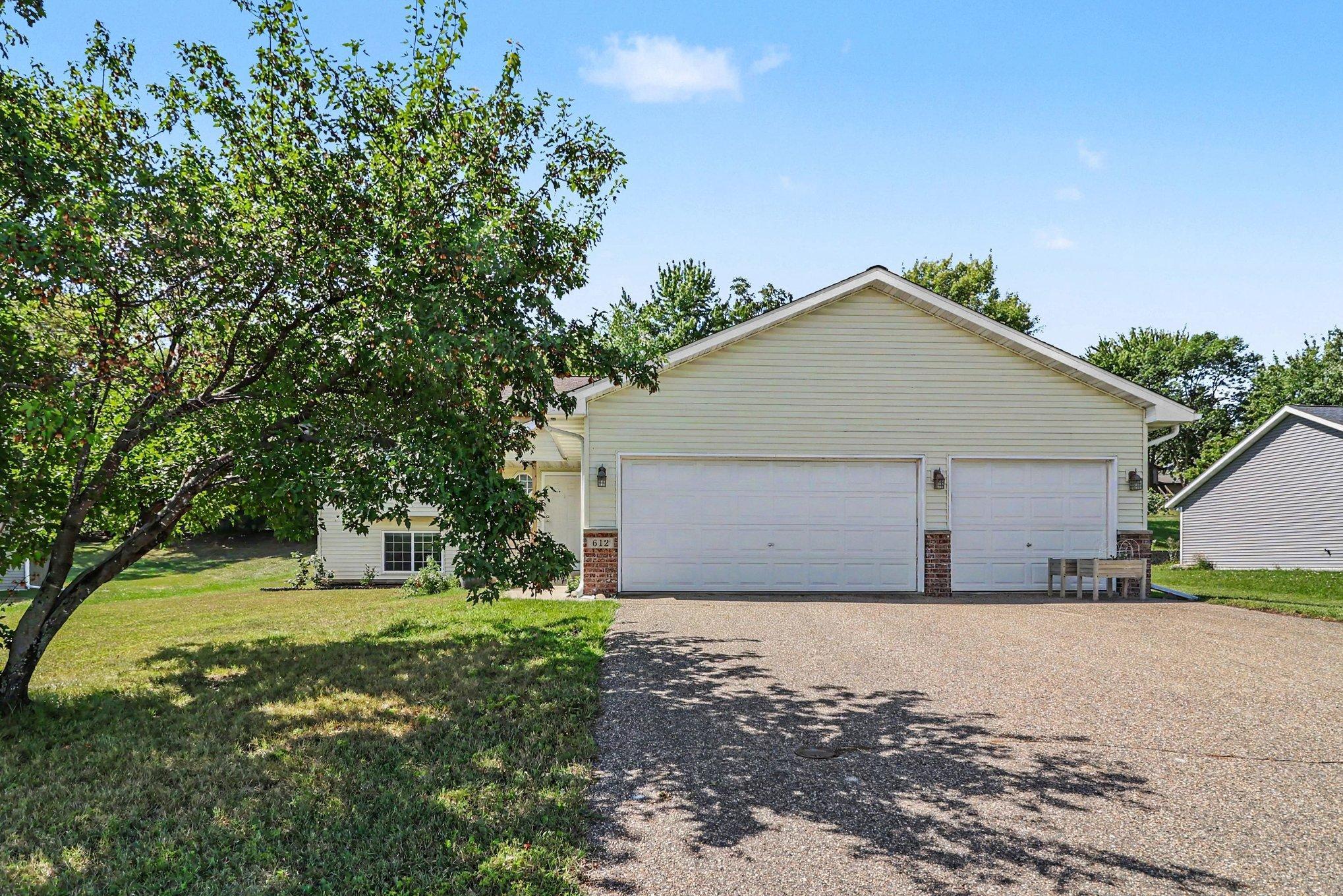 Daylight front exterior of this Montgomery home, showing the three-car garage and established lot.