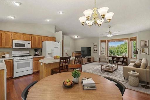 Open dining and kitchen area with island seating and vaulted ceiling. (virtually staged to show potential layout)