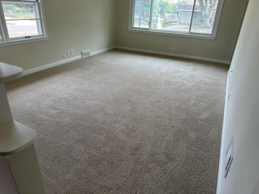 Main floor living room with ceiling fans and plenty of natural lighting.