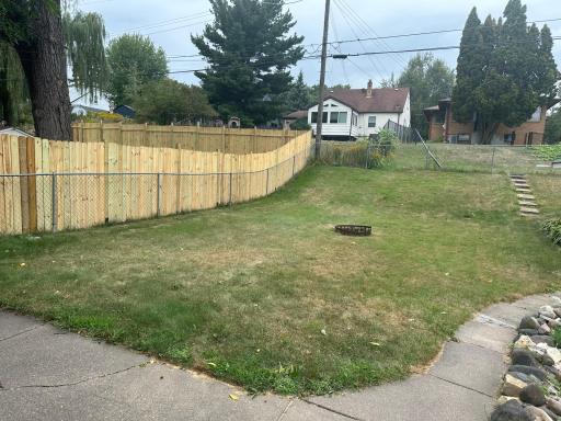 Back yard with a chain link fence and bonus 6 ft privacy fence that's the neighbors.