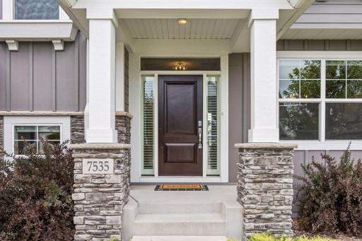 LP siding with natural stone exterior and concrete driveway