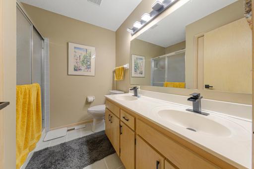 Upper-level 3/4 bathroom with dual vanity and walk-in shower