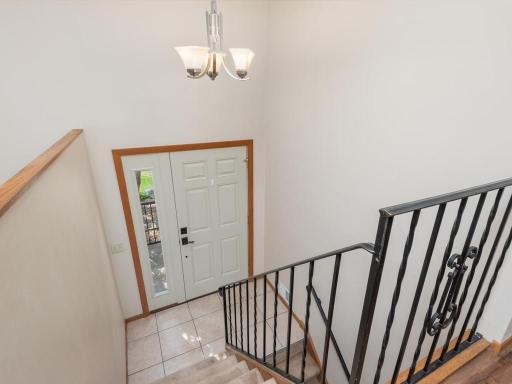 Newer front door with sidelight welcomes guests to a bright entryway with tile flooring.