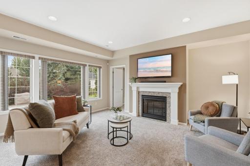 Living room with large windows, entrance to primary bedroom