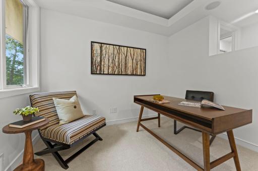 Main floor office with glass block wall, custom built-ins and massive windows looking out into nature
