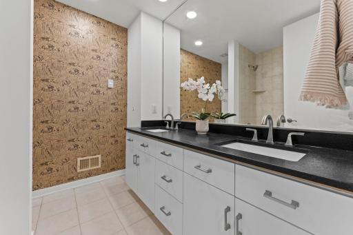 Lower level bathroom with double vanity, heated floor tiles, new granite and tops, undermount sinks, and fixtures.
