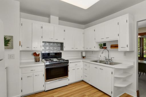 The bright, spacious kitchen includes lots of cabinetry and shelves for storage