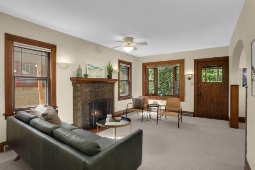 The main level includes beautiful living spaces, including a classic brick fireplace and beautiful bay windows that look out to the parkway