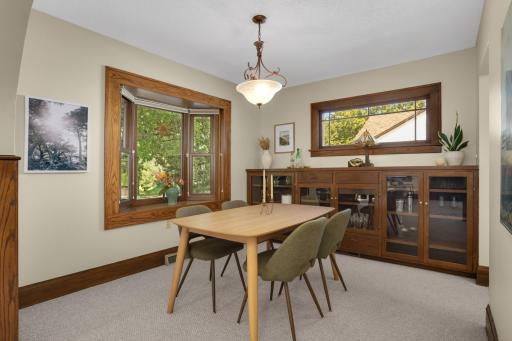 The dining room features a large built-in cabinet that provides lots of convenient storage space and beautiful windows