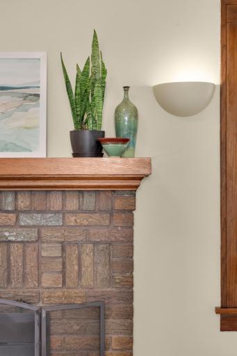 Beautiful brick fireplace framed by sconse lighting