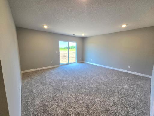 The Rushmore Walkout Lower Level Family Room at Highlands at Eagle View in Elko New Market. Photo is of similar home. Options and colors may vary. Ask Sales Agent for details.