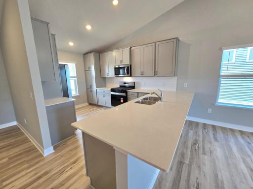 The Rushmore kitchen shown with Willow cabinets at Highlands at Eagle View in Elko New Market. Photo is of similar home. Options and colors may vary. Ask Sales Agent for details.