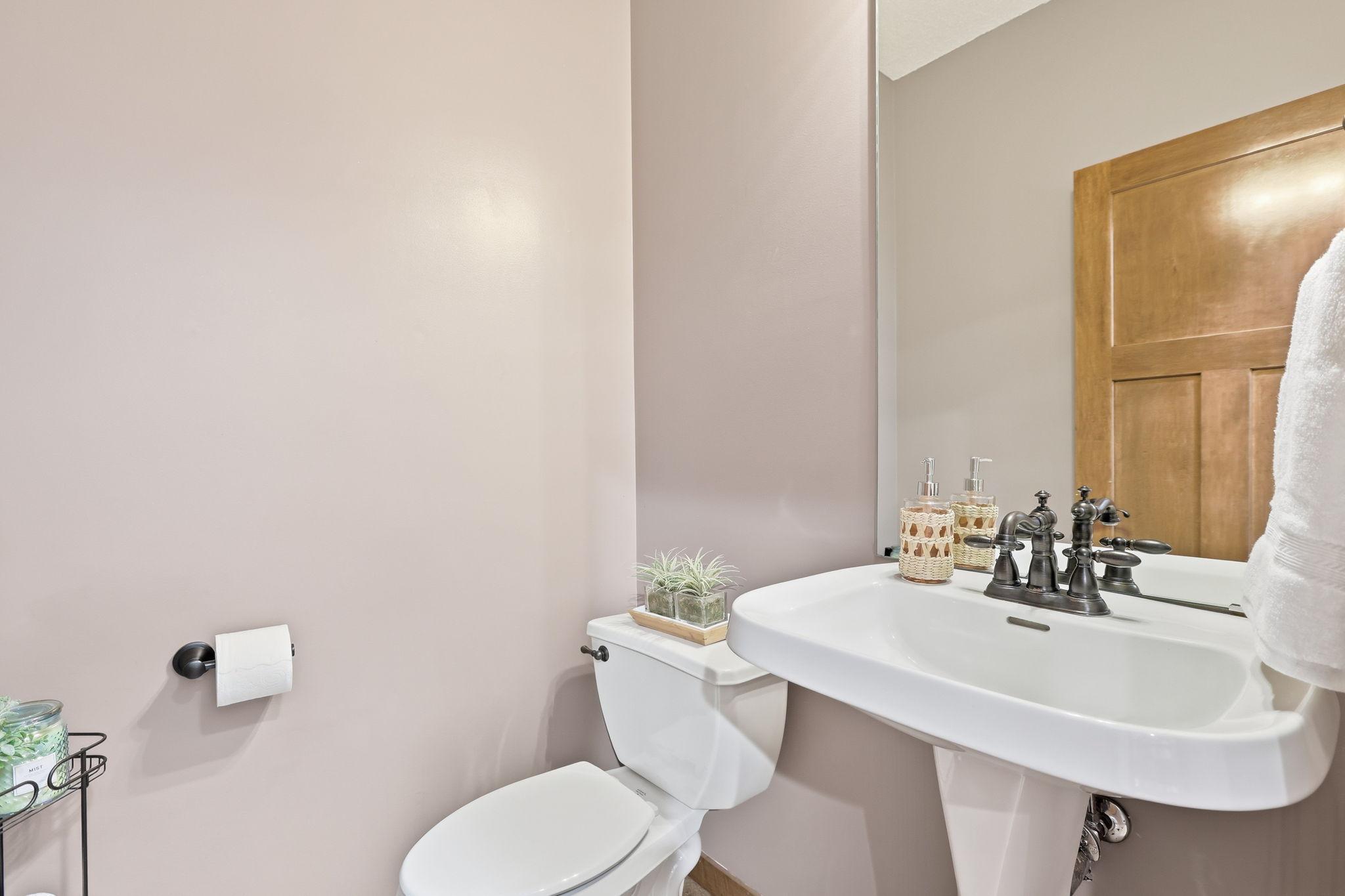 The main-level 1/4 bath is located just steps from the garage entry, laundry room, and drop-zone mudroom.