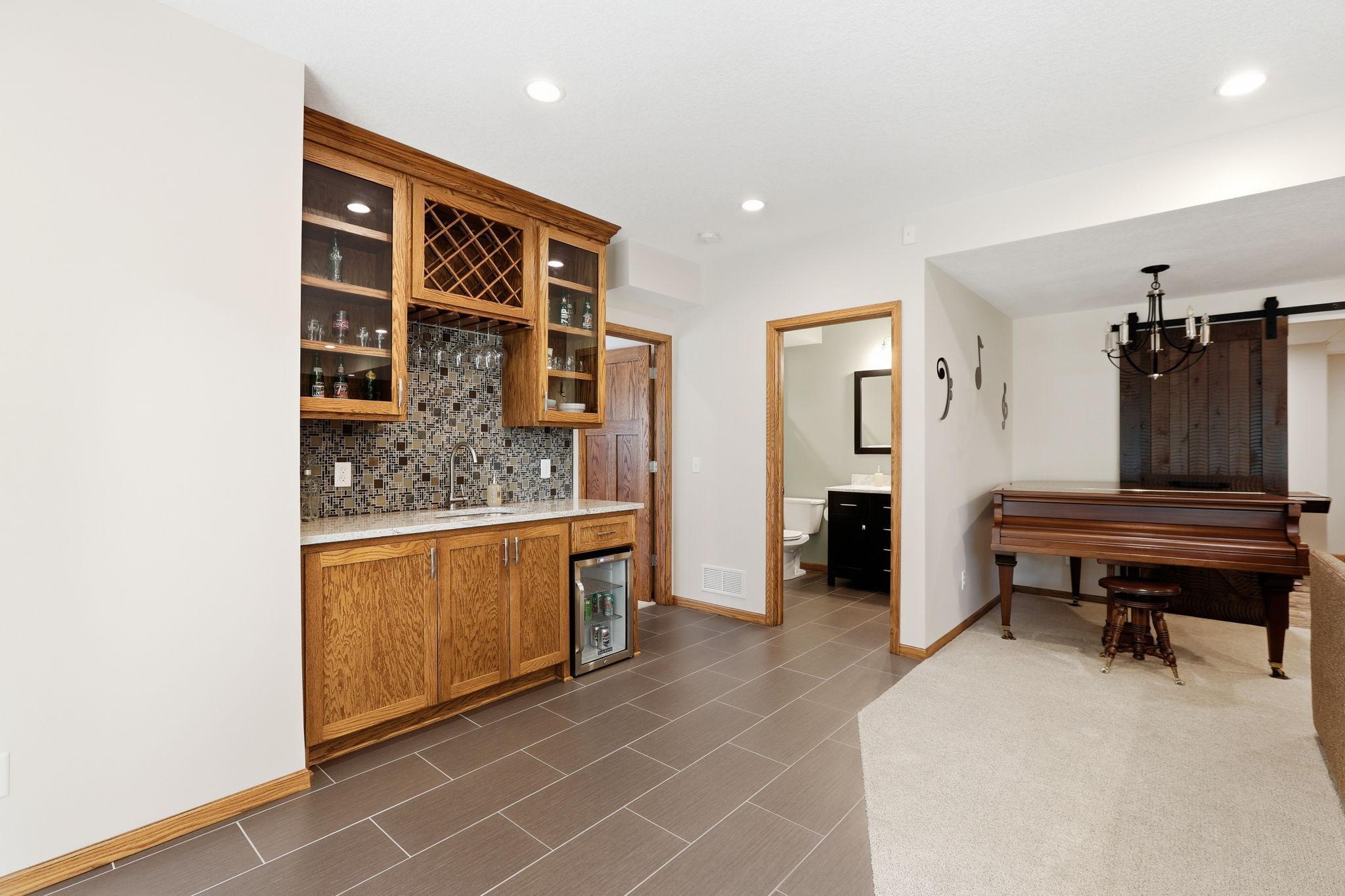 Located directly adjacent to the lower level bedroom, the lower level full bathroom, and the entertainment room plus the game room, this spot is perfect for a quick snack or beverage.