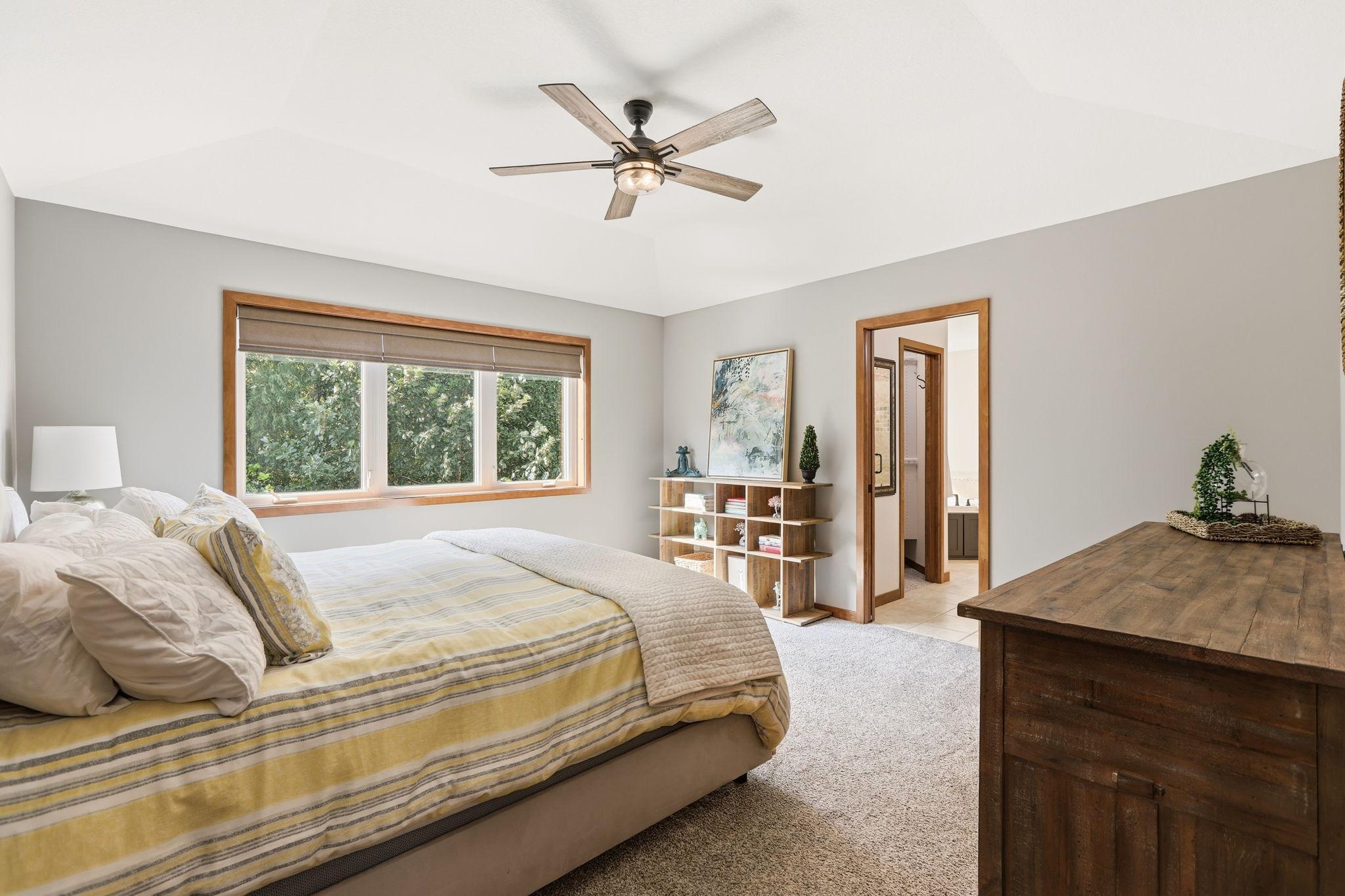 Your updated primary bedroom sparkles with light and overlooks the beautiful backyard.
