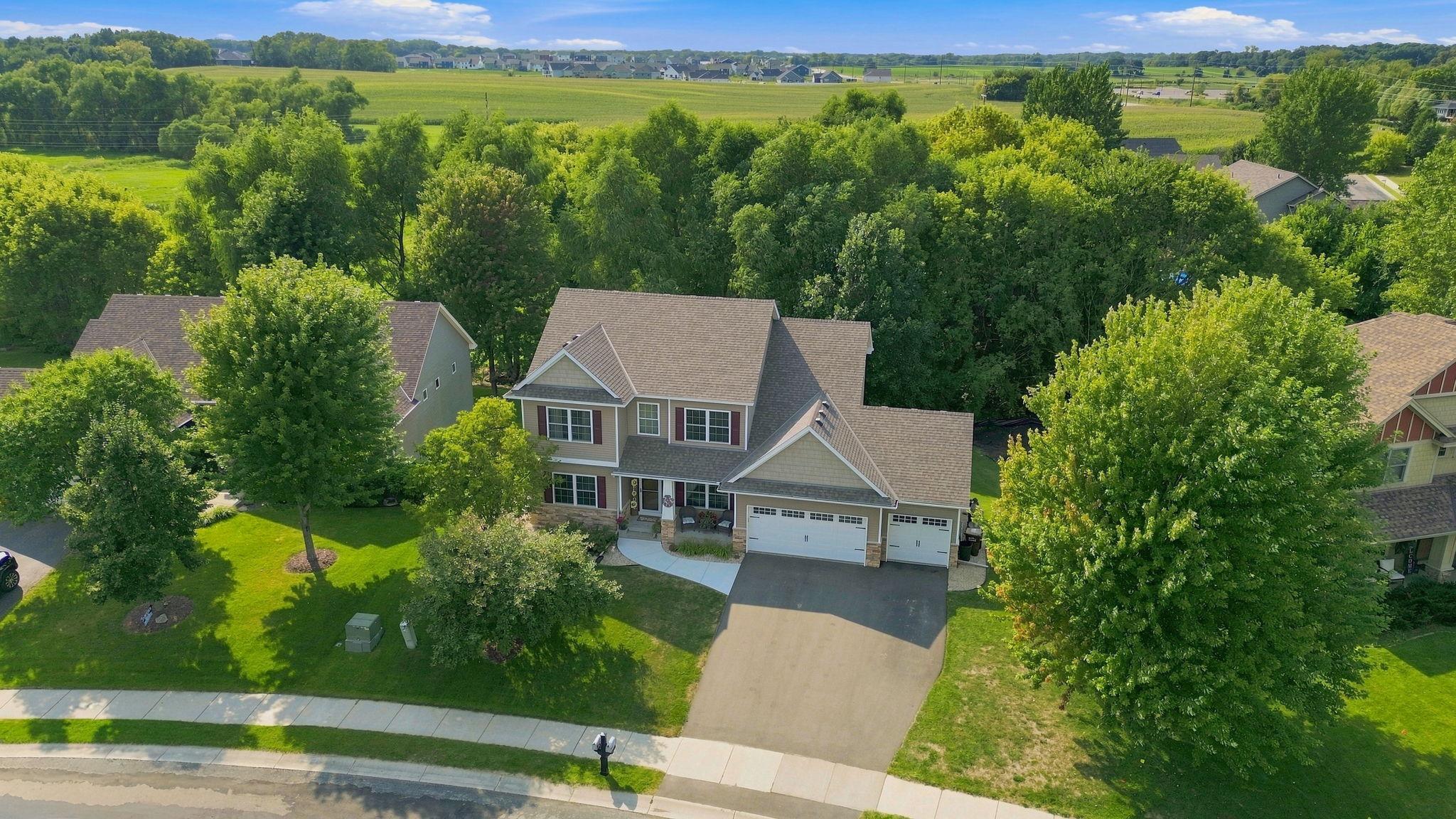 Drone shot of your new home and a view of the wooded area behind the home.