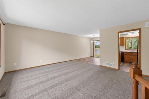 Living room flows seamlessly into the dining area with sliding glass door access with beautiful backyard water views.