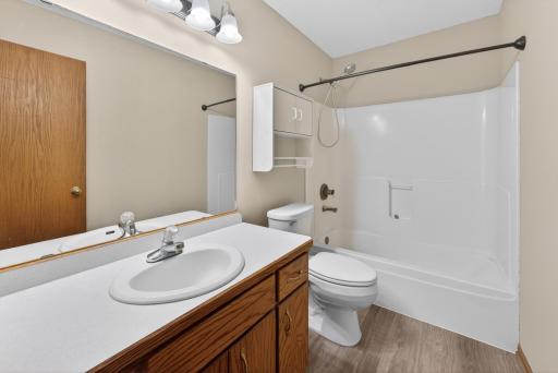 Upper-level full bathroom featuring tub/shower combination, oversized vanity mirror, and convenient access to the upper-level bedrooms.