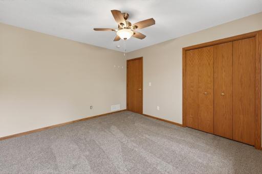Comfortable upper-level bedroom featuring neutral finishes, updated carpeting, and generous closet space.