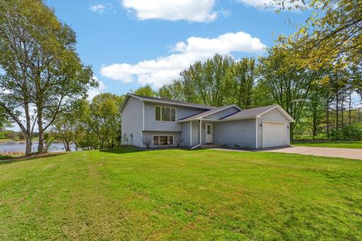 Beautiful waterfront setting surrounded by mature trees, open green space, and scenic natural views in every direction.