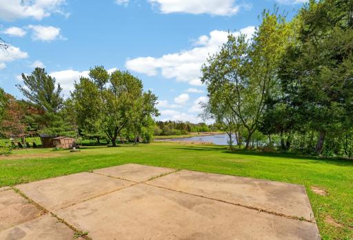 Relax and unwind in the tranquil backyard setting overlooking the calm waters and natural shoreline landscape.