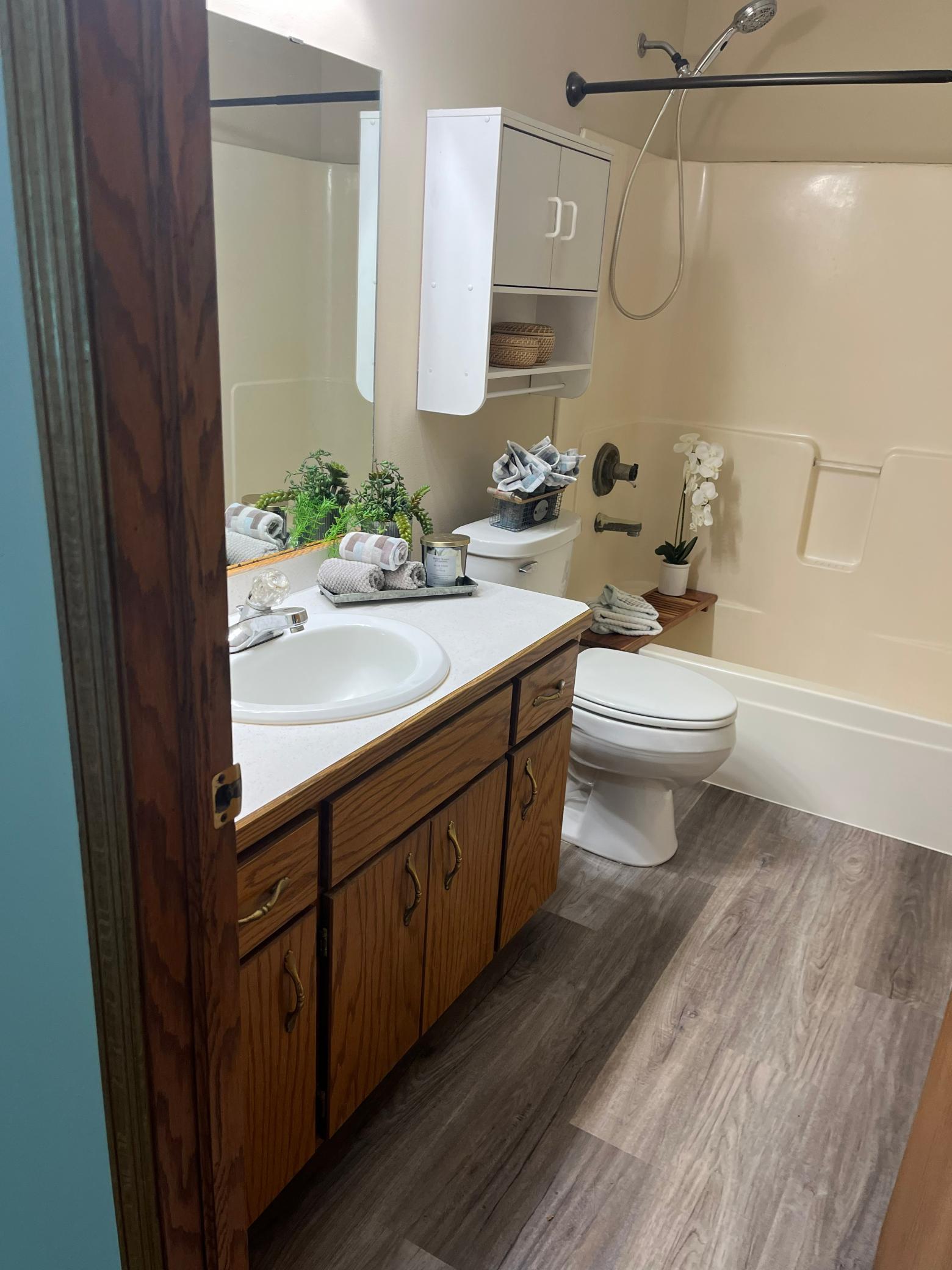 Upper-level full bathroom featuring tub/shower combination, oversized vanity mirror, and convenient access to the upper-level bedrooms.