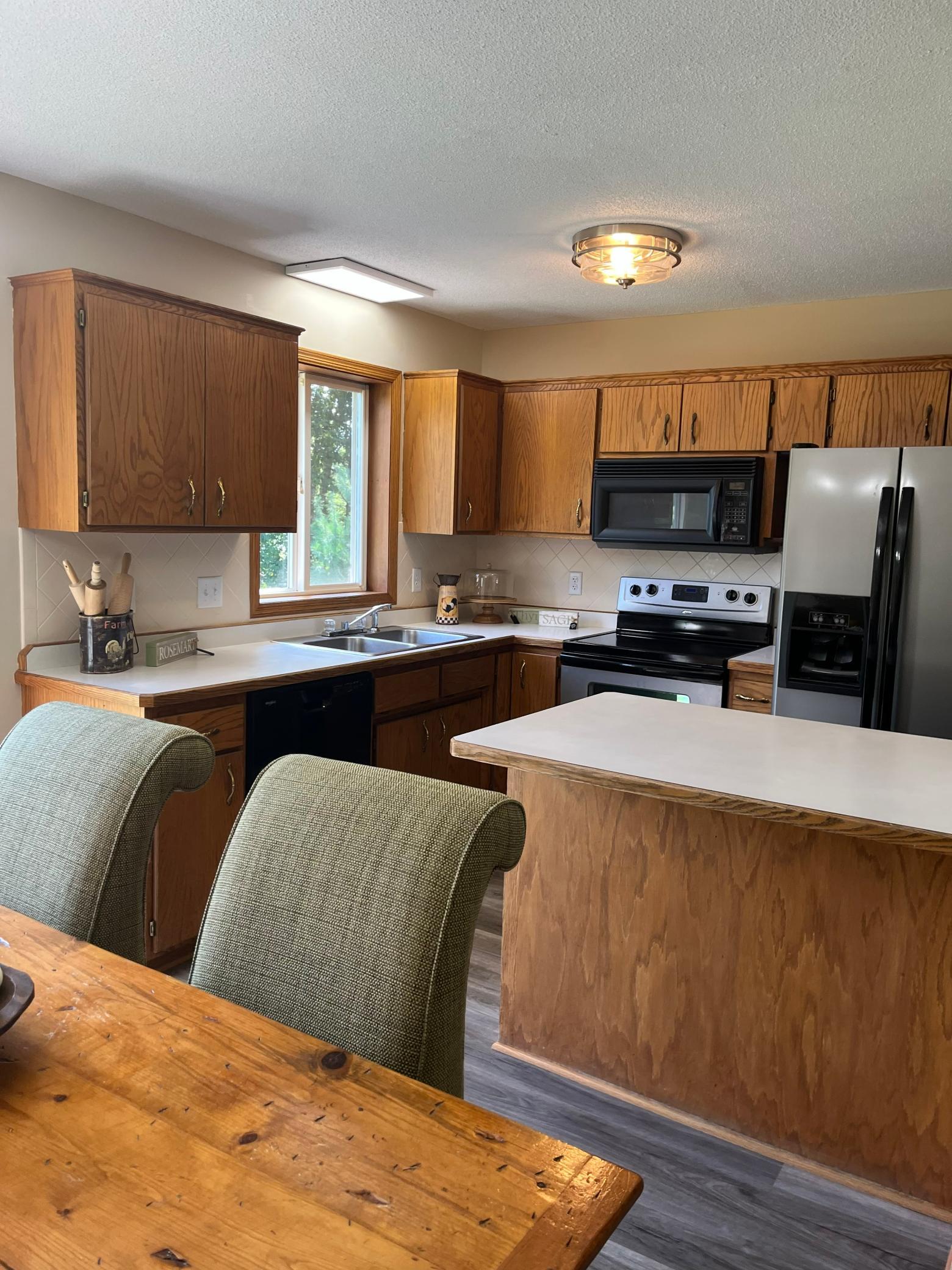 Welcoming eat-in kitchen offers generous cabinet storage, abundant natural light, and easy access to the backyard through the sliding patio door.