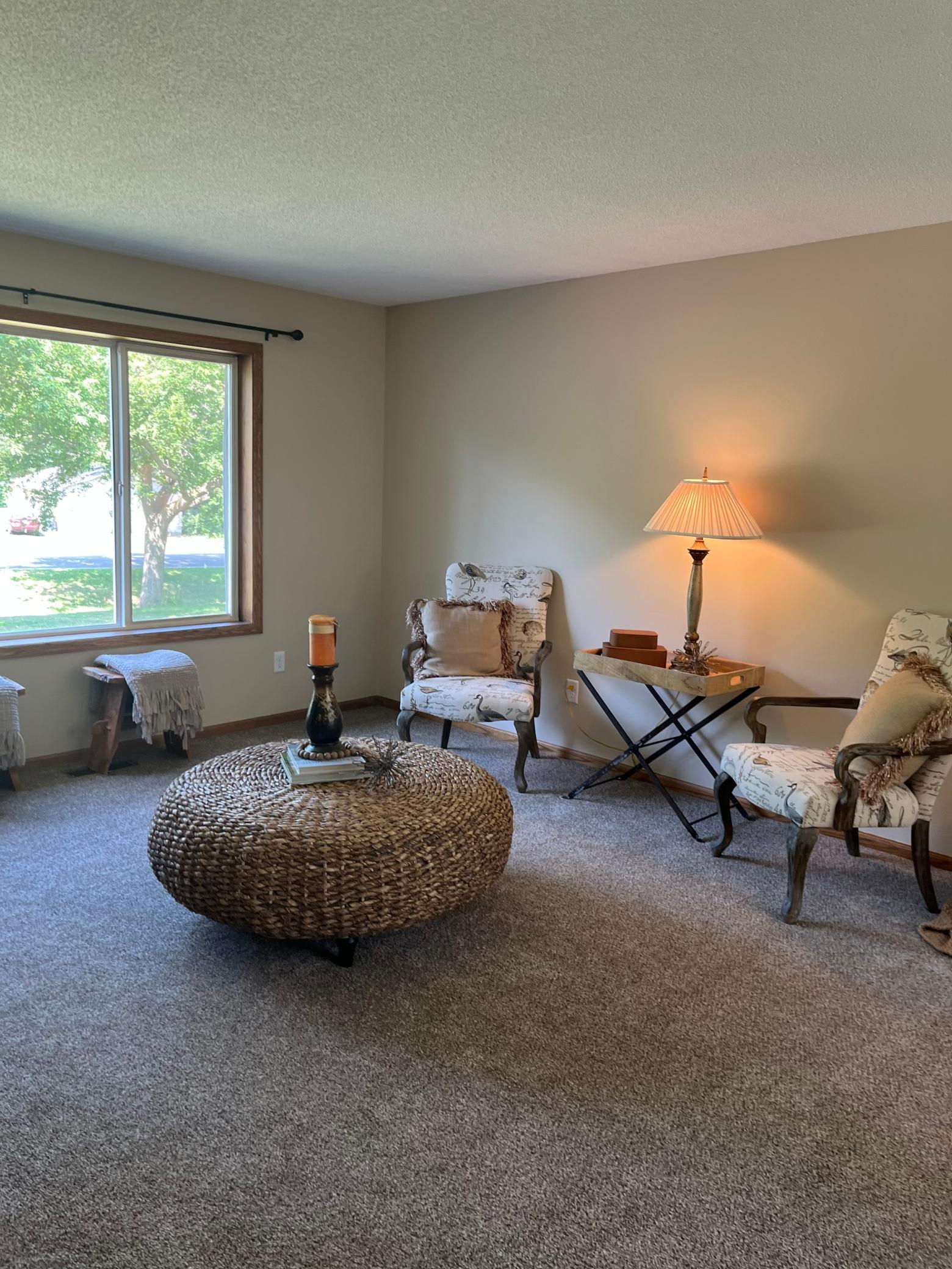 Spacious upper-level living room with abundant natural light, neutral finishes, and an open layout connecting to the dining and kitchen areas.