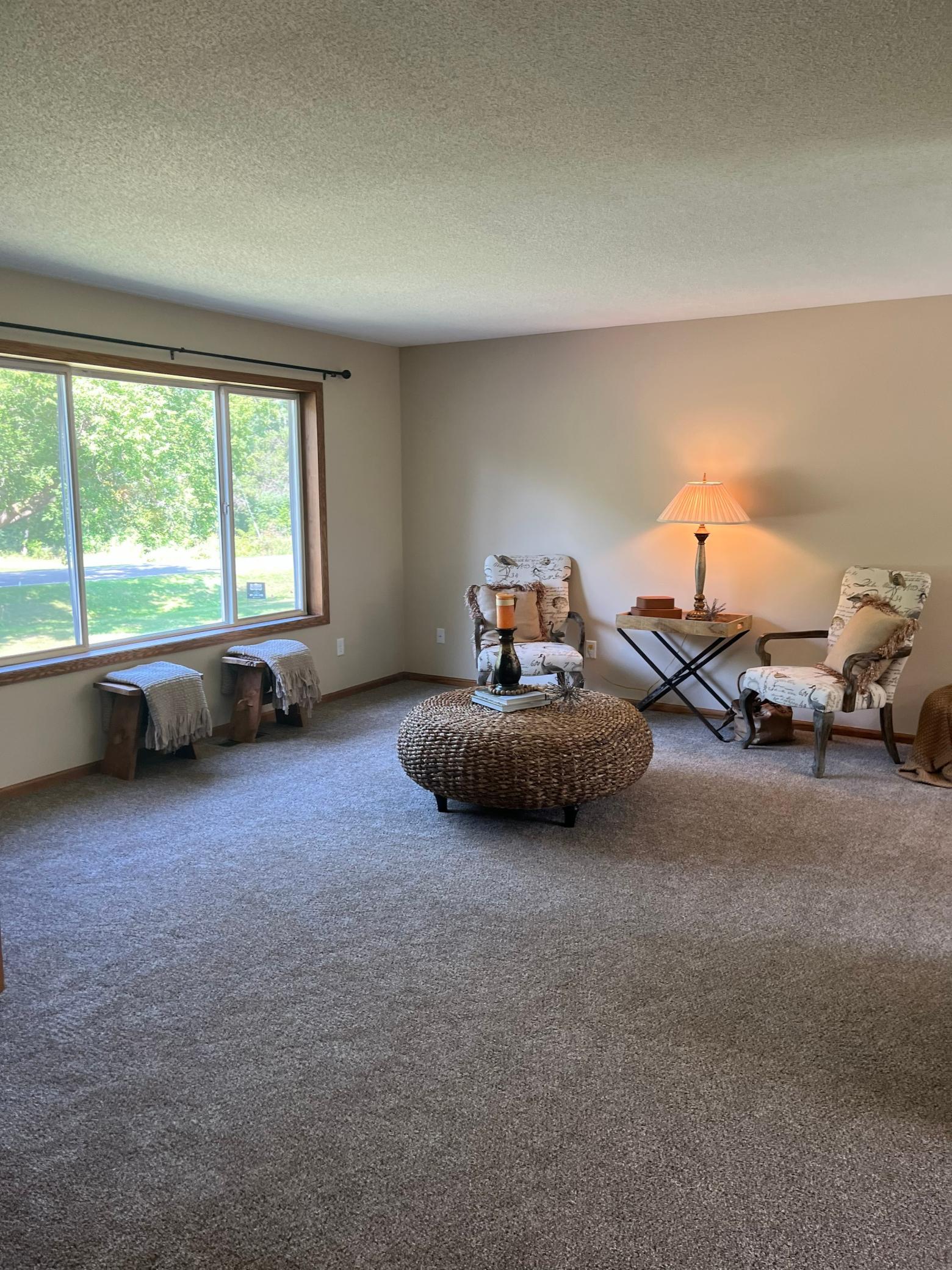 Abundant natural light, neutral finishes, and an open layout connecting to the dining and kitchen areas.