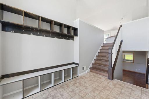 The spacious entryway features tall ceilings, a welcoming light fixture, and impressive built-in storage, creating a convenient and stylish connection between the garage and living space.