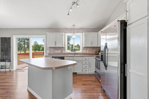 Crisp white cabinets, a stylish stone backsplash, and stainless-steel appliances make this kitchen visually appealing and highly functional.