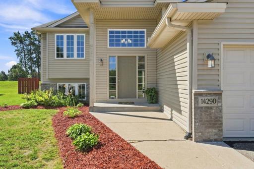 A sheltered front entrance offers an inviting welcome with nice landscaping.