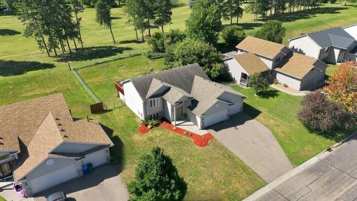 The generous yard provides plenty of room for outdoor living, gardening, or recreation, while the open green space beyond creates a scenic, private feel.