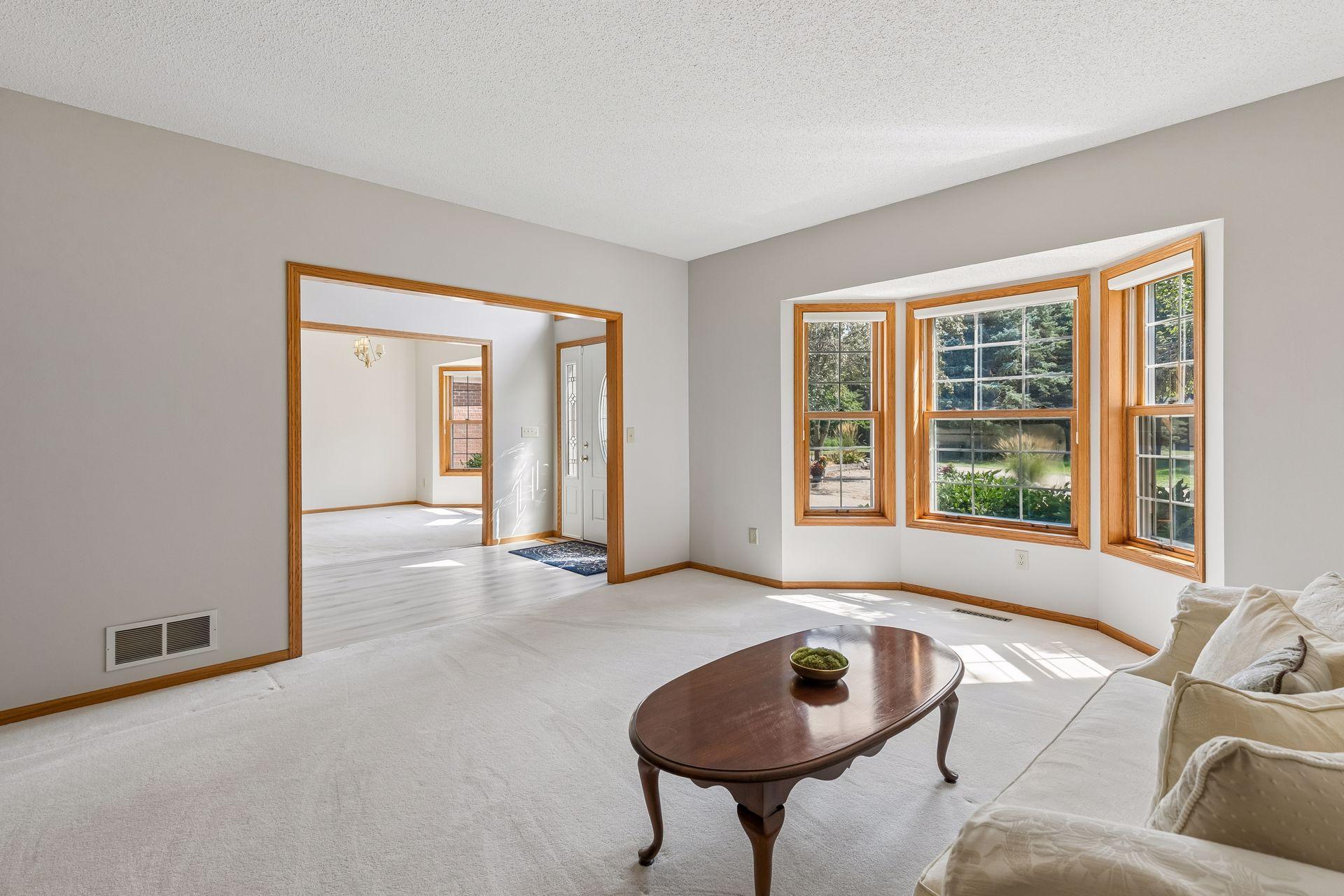 Expansive windows fill the front sitting room with natural light while offering peaceful views of the surrounding acreage.