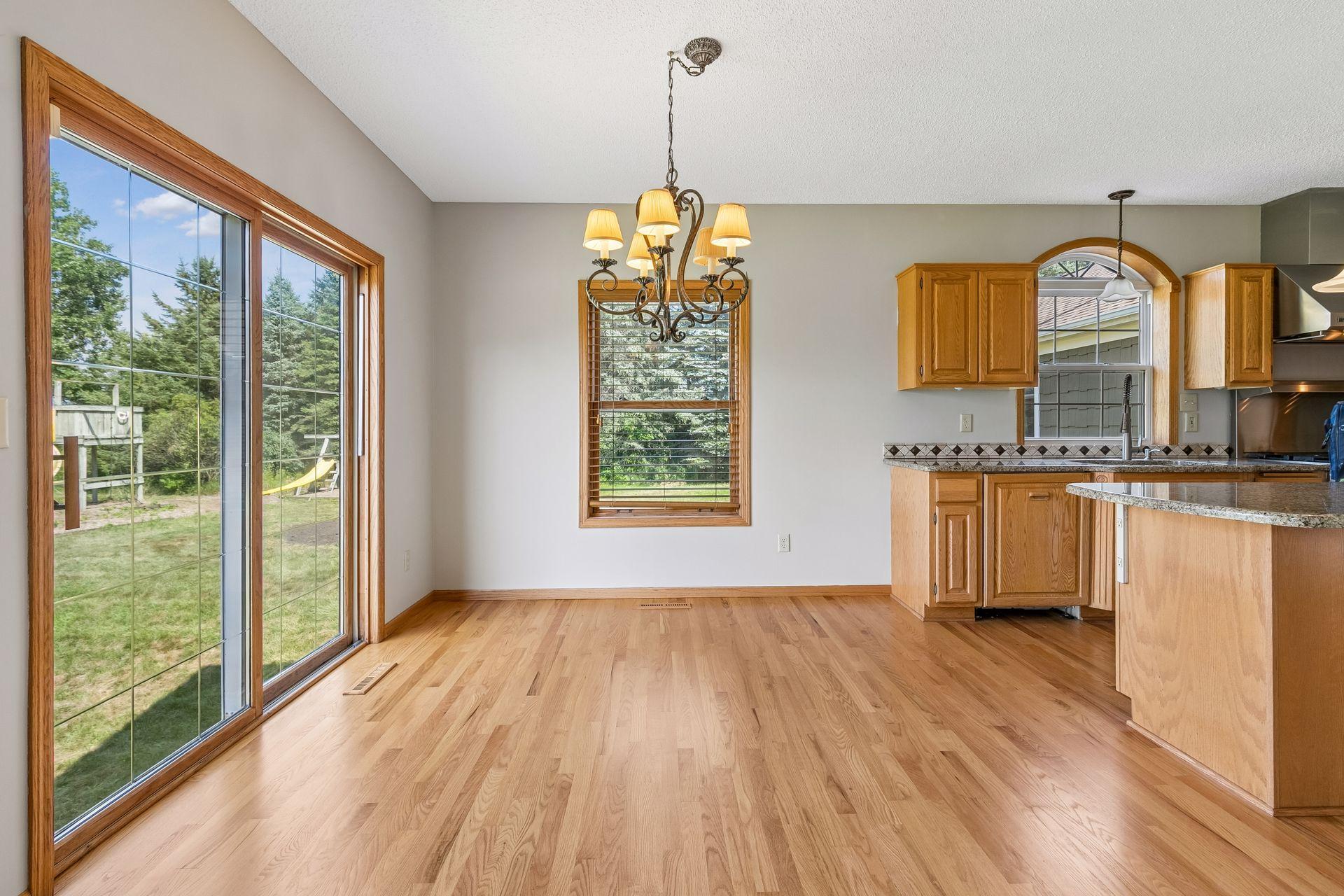 Welcome to the kitchen! A sunny dining area provides the perfect spot for everyday meals, complemented by recently refinished hardwood floors.