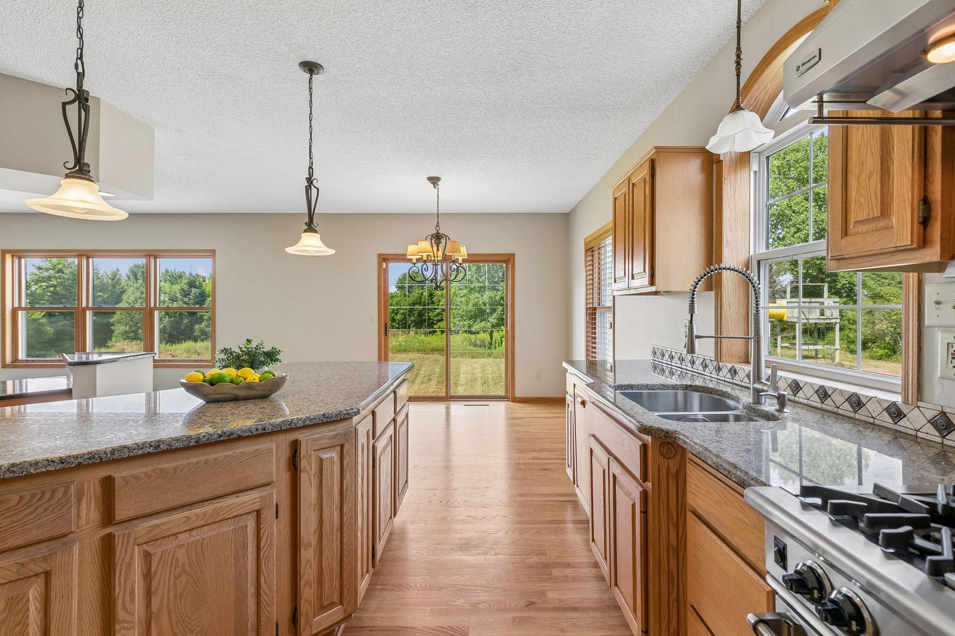 Standing near the Sub-Zero refrigerator, this view showcases the impressive scale of the kitchen, expansive island and wonderful connection to the surrounding living spaces.
