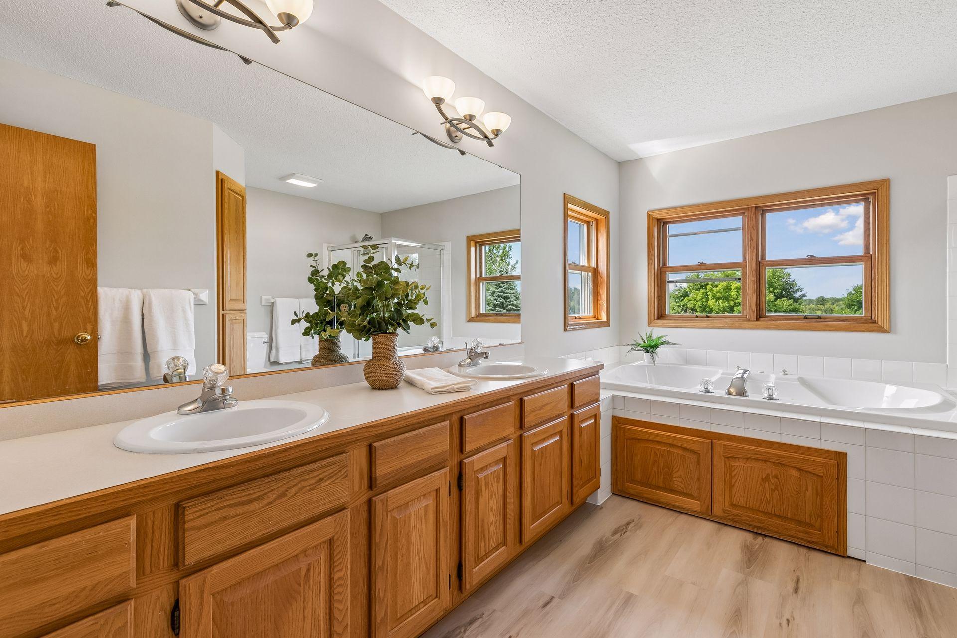 The primary bathroom features dual sinks, ample vanity space and a peaceful view overlooking the backyard and surrounding acreage.