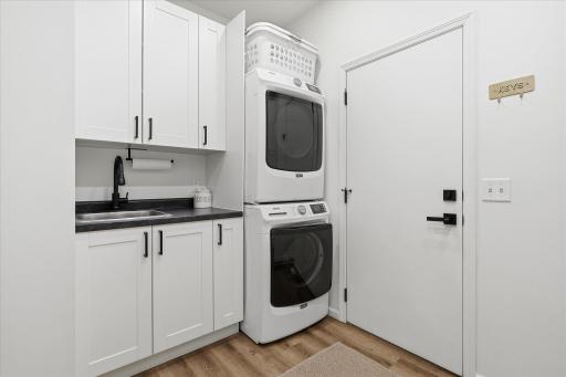 This laundry/mud room features high-efficiency laundry machines, a sink and so much storage.
