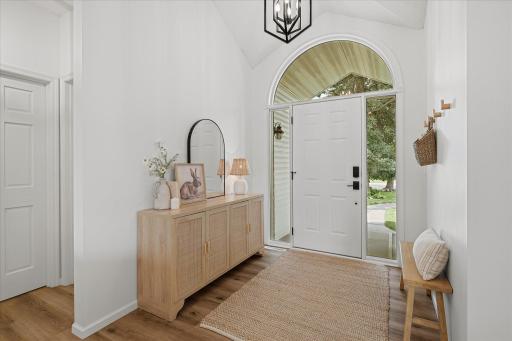 The bright foyer features a huge transom window and two sidelights to allow so much natural light in, and the modern & bright paint adds even more to that!