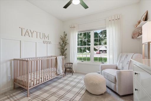 This is the front bedroom on the opposite side of the home from the primary suite. It features cordless room-darkening honeycomb shades, a ceiling fan w/separate light & fan switches, and a board & batten feature wall.