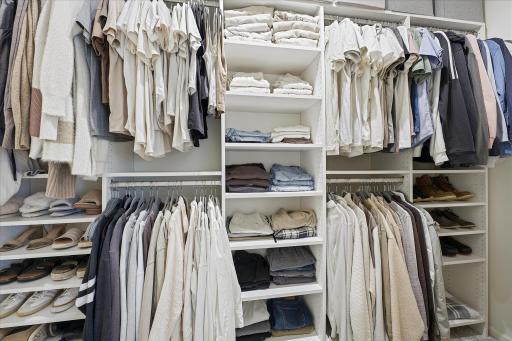 The walk-in closet features a custom organizer system.