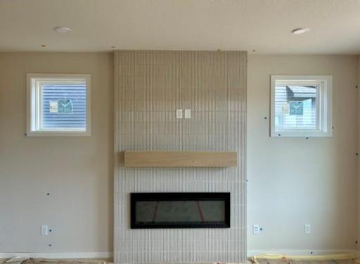 Floor to ceiling tiled fireplace flanked by two additional windows.jpg