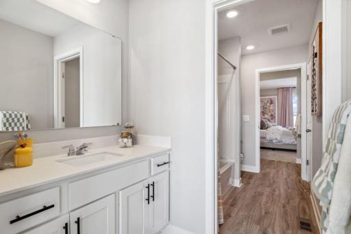 Jack and Jill bathroom with sinks for each individual bedroom. Only area shared is the shower/bath and toilet room. Photo of a model home, color & options will vary.