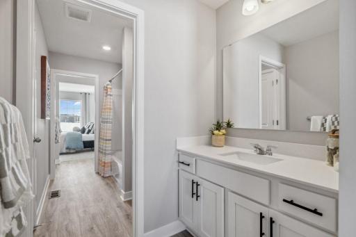 Jack and Jill bathroom with sinks for each individual bedroom. Only area shared is the shower/bath and toilet room. Photo of a model home, color & options will vary.