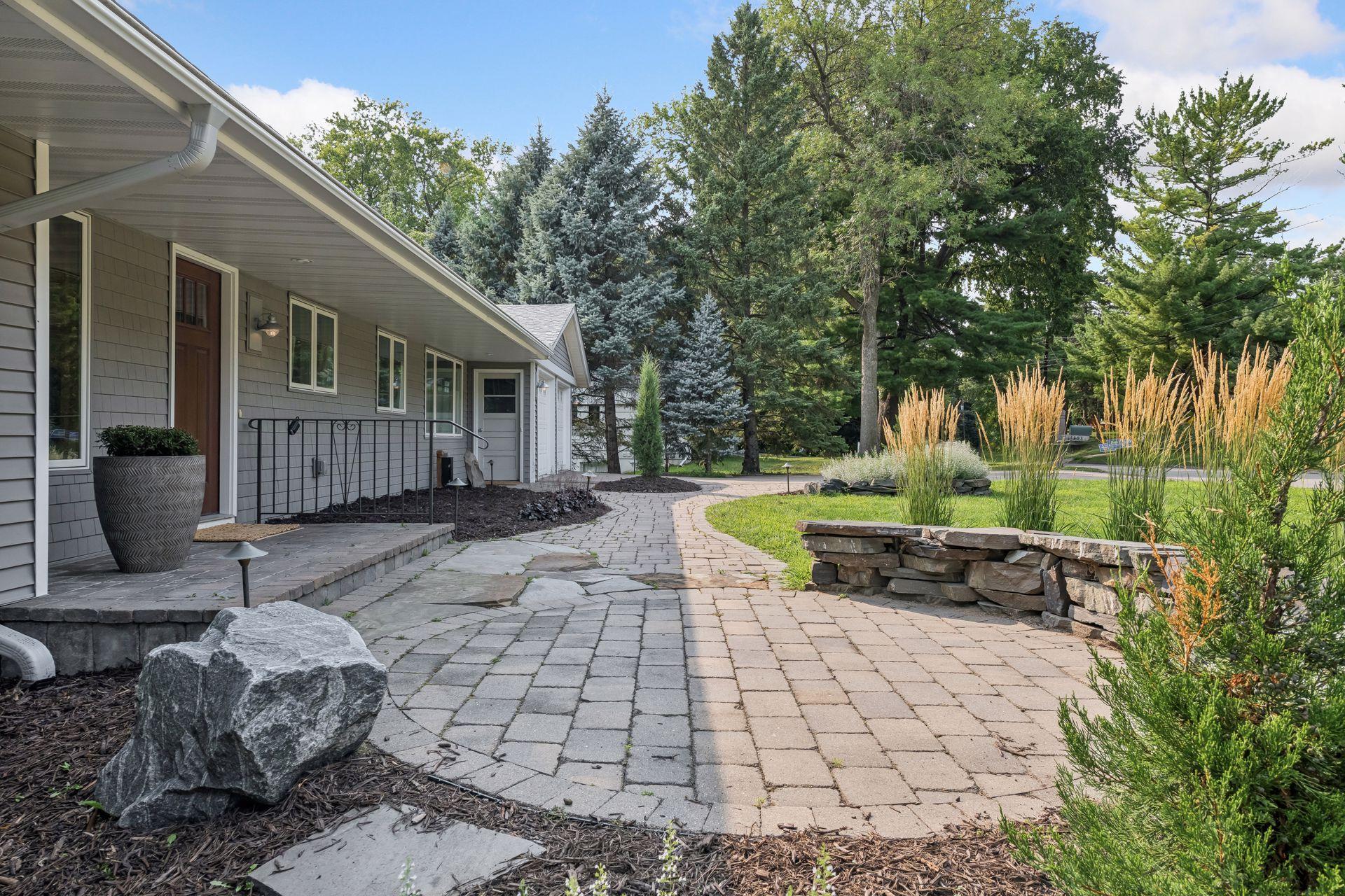 Outside, enjoy the privacy of the expansive lot with mature surroundings, paver walkway and patio, deck, and attached two-car garage.
