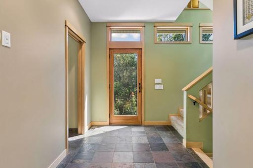 The entry door faces east, giving morning light to the slate floor.