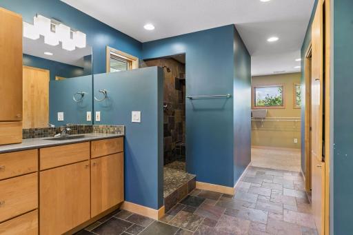 The slate floor leads to the walk-in shower with slate wall and floor tiling.
