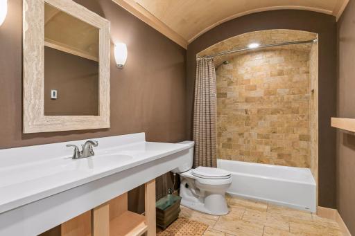 Lower-level full bath is a showstopper! The travertine tile floor is heated, with travertine walls in bath tub/shower, curved maple ceiling.