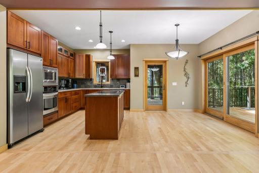 Imagine enjoying this space while you dine and take in the views through the expansive sliding-door window that opens to the deck, or the glass door leading to an oversized screened porch.